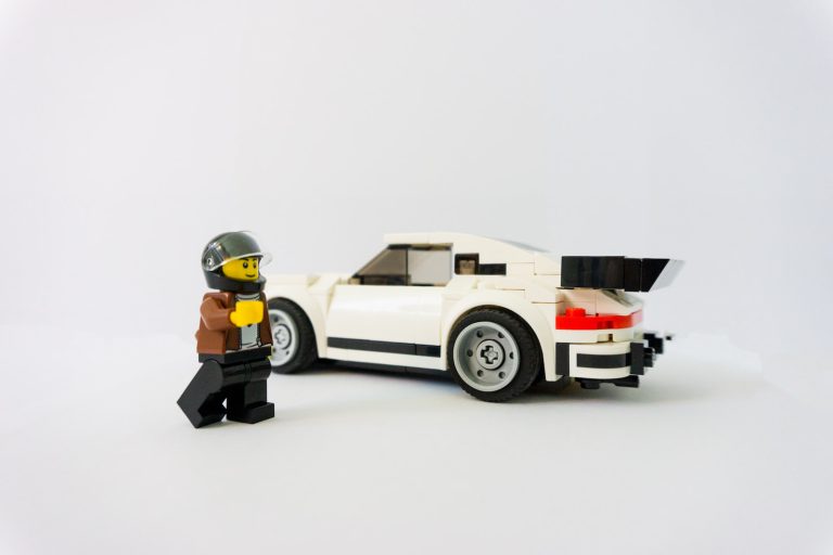 Lego minifigure beside car toy