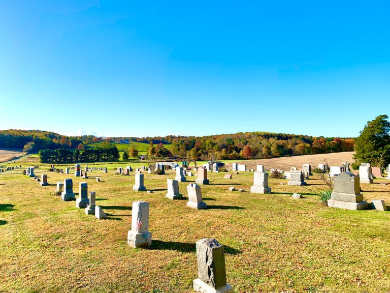 white cross on green grass field during daytime