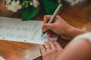 a person writing on a piece of paper with a pen