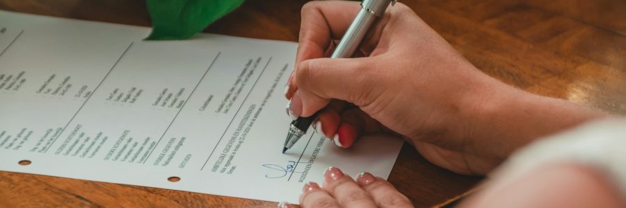 a person writing on a piece of paper with a pen